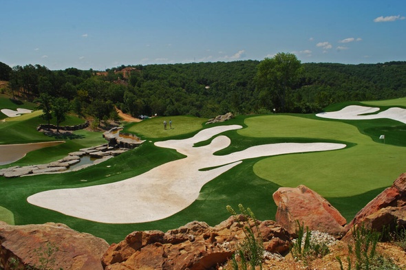 Greenwich lush green synthetic grass golf course with white sand bunkers and blue sky